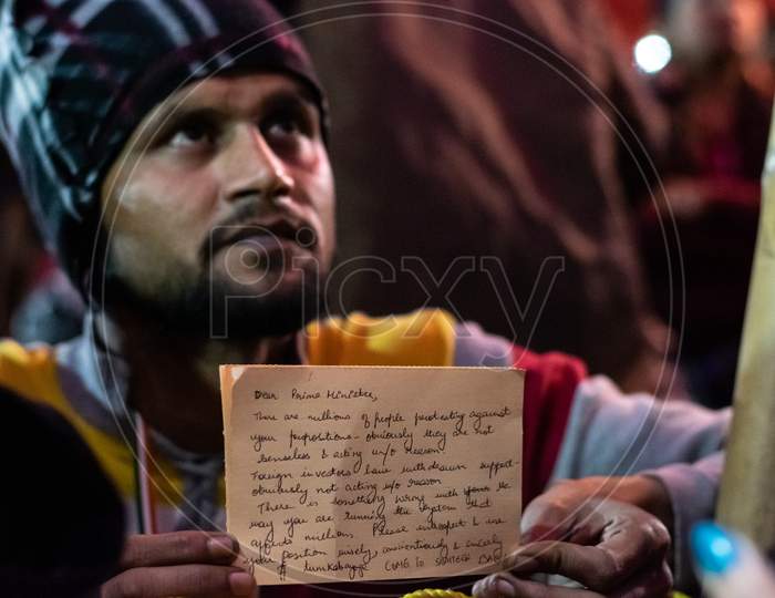 A man showing postcard written to Prime minister at Shaheen Bagh