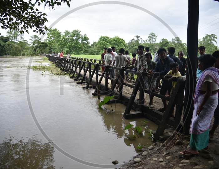 Villagers Crossing a Water Channel Over Wooden Bridge