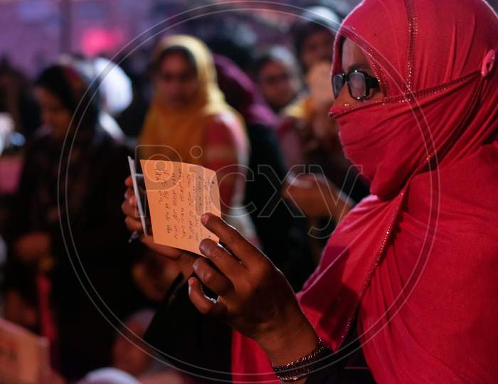 A woman showing postcards written to Prime minister at Shaheen Bagh