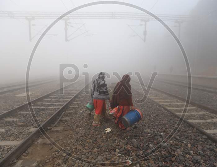 People Crossing Railway Track on a Misty Mornings