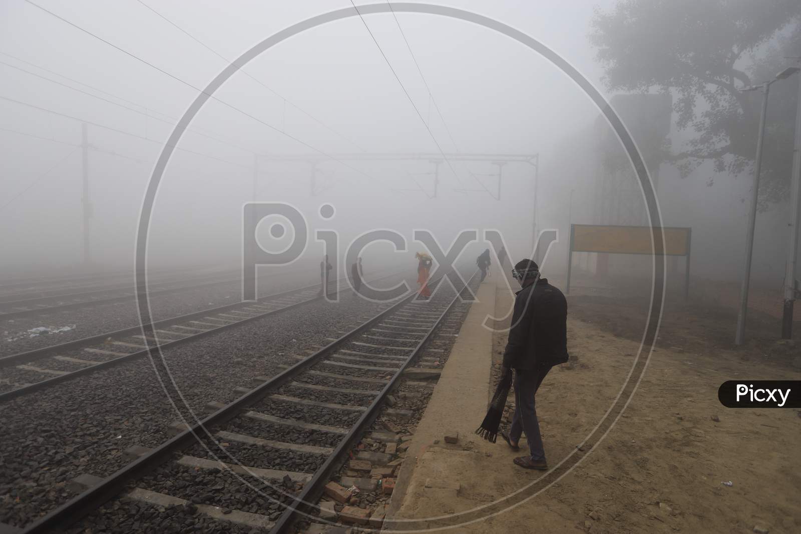 Passengers in an Railway Station Platform In an Misty Winter Morning