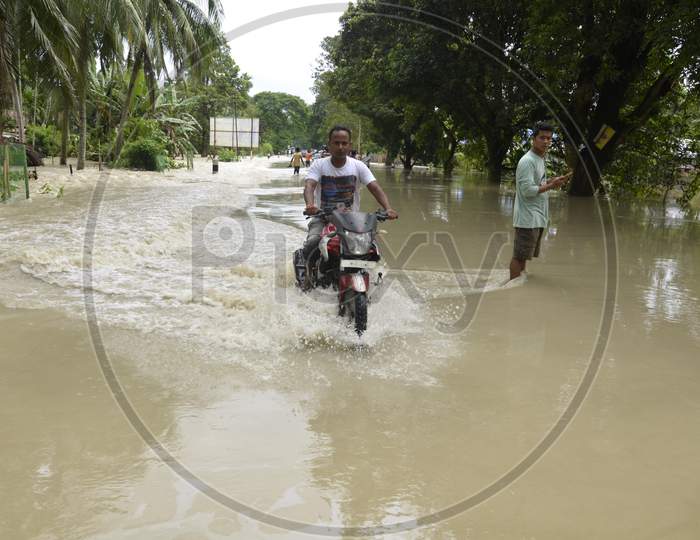 People Riding Bikes On Flooded Roads