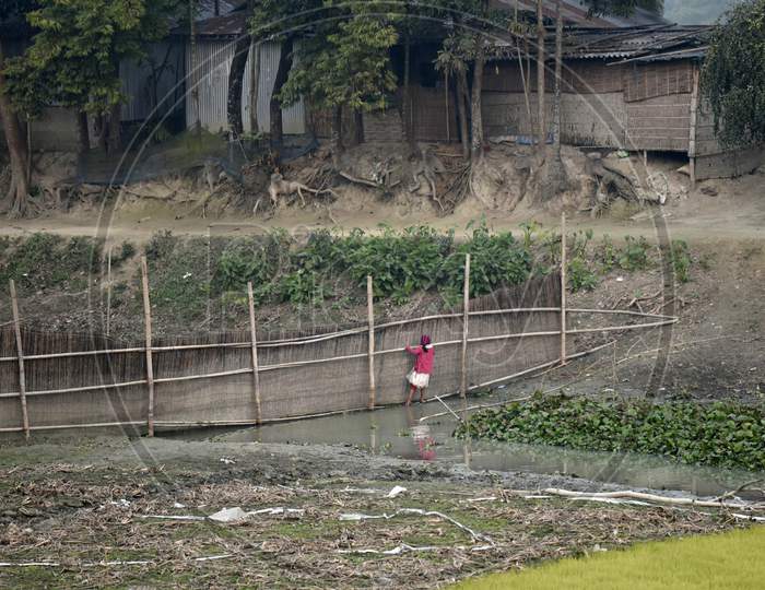 A Girl Crossing A Water Stream, At Kayakuchi Village, In Barpeta District Of Assam
