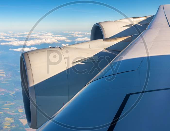 Wing With Engines Of Airbus A380 Flying Over Clouds