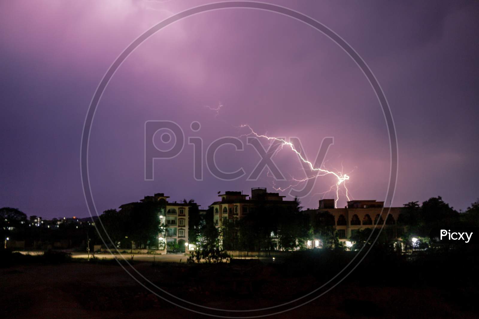 Lightning Spark Over City Scape Houses  With Blue Hour Sky in Background