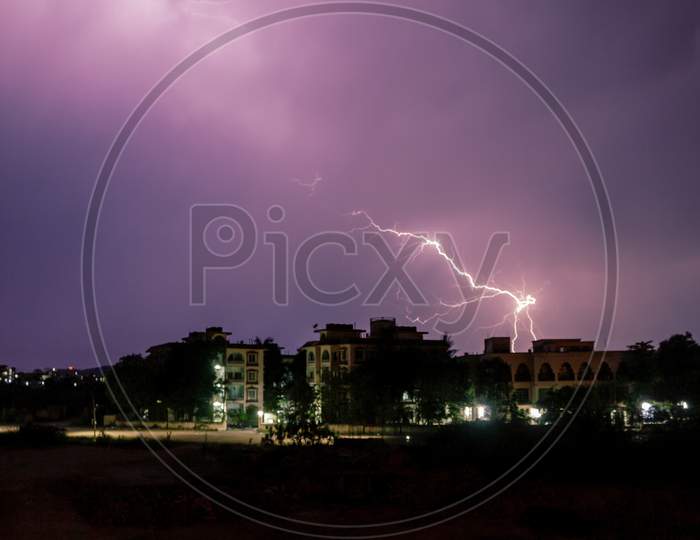 Lightning Spark Over City Scape Houses  With Blue Hour Sky in Background