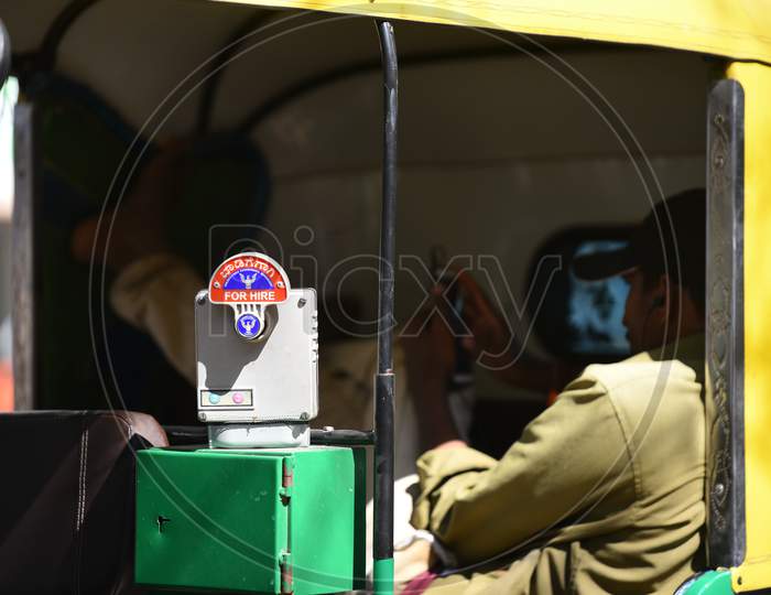 A hire auto driver rests inside his vehicle