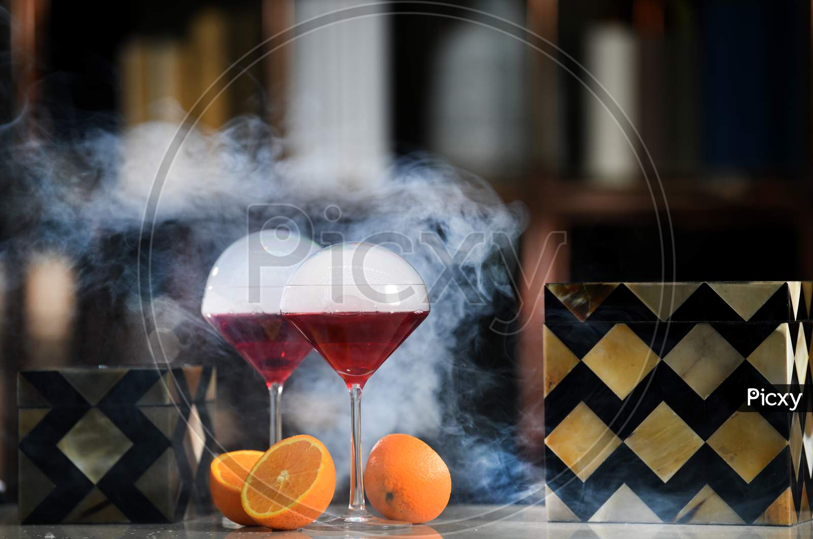 Red Grape Wine Or Juice In an Mocktail Or  Cocktail Glass With Orange Fruit Cut   Pieces  At a Pub Counter Background