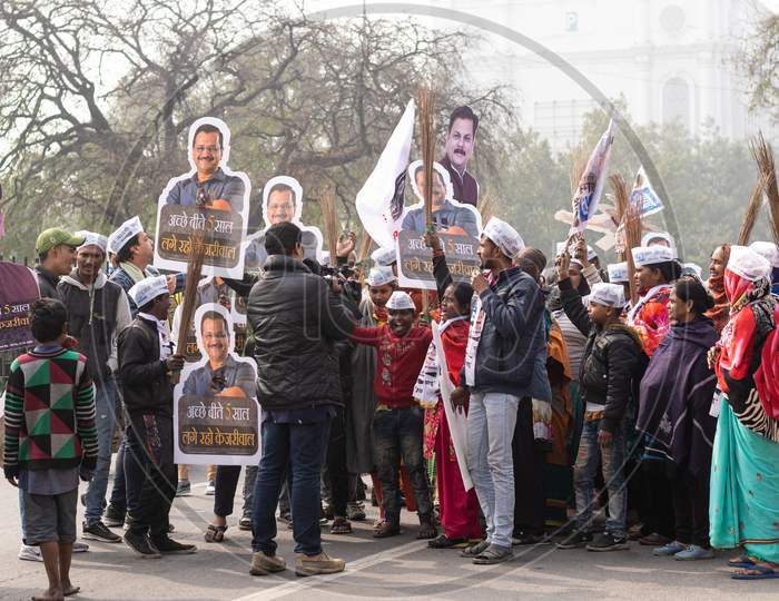 Aam Aadmi Party AAP supporters holding cutout of Arvind Kejriwal and brooms during a rally for Delhi Assembly Election