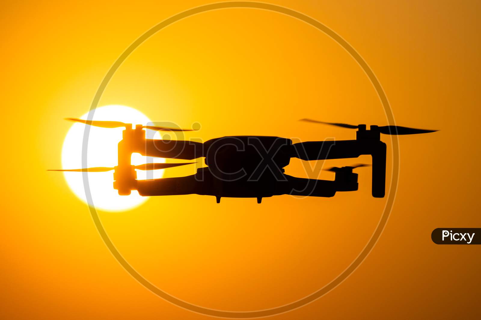Silhouette Of DJI Mavic Mini Drone Over Sunset Sun In Background
