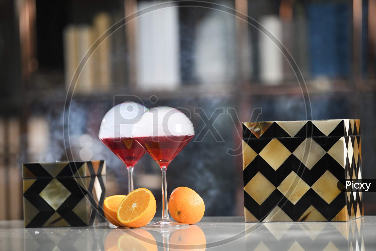 Red Grape Wine Or Juice In an Mocktail Or  Cocktail Glass With Orange Fruit Cut   Pieces  At a Pub Counter Background