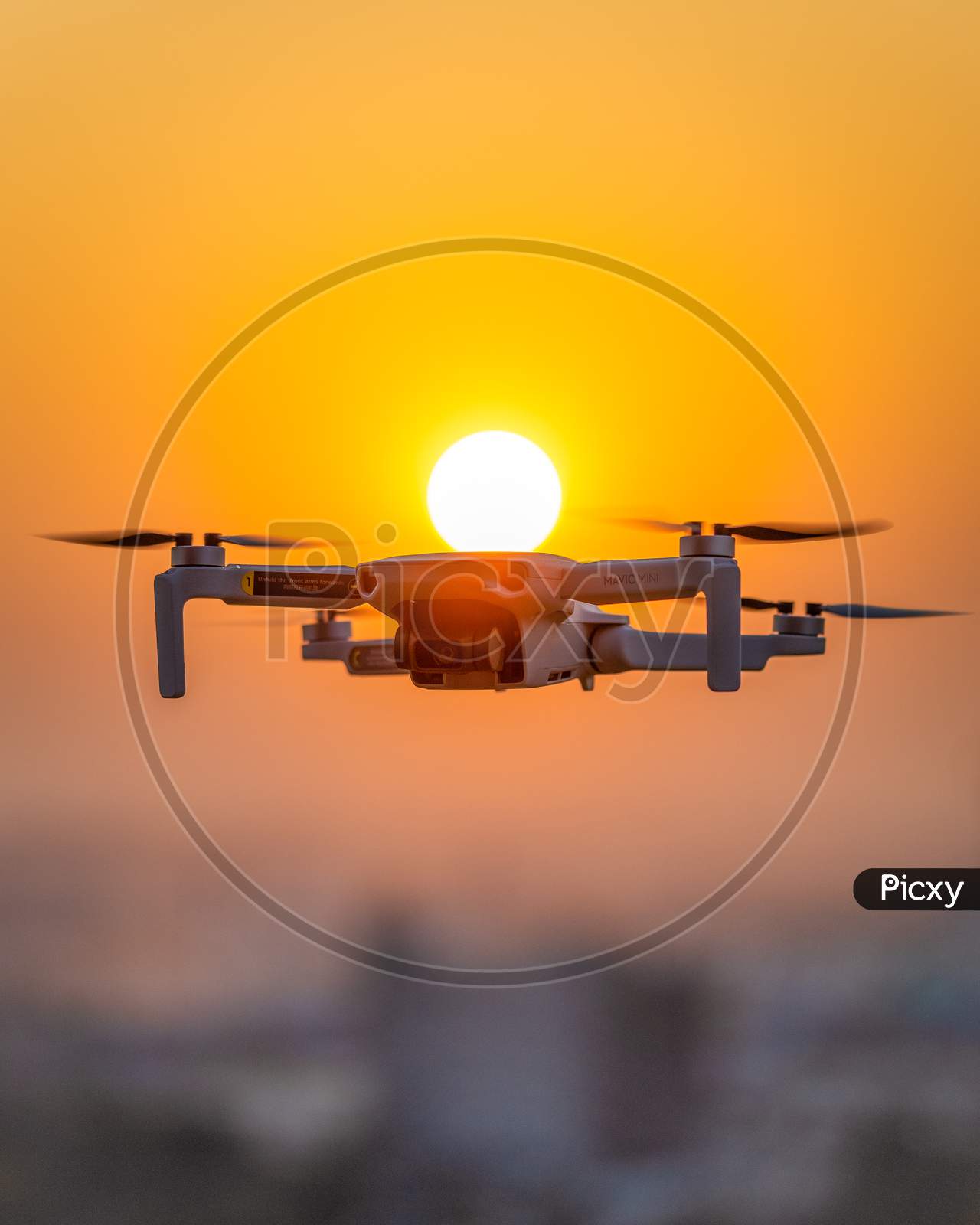 Silhouette Of DJI Mavic Mini Drone Over Sunset Sun In Background