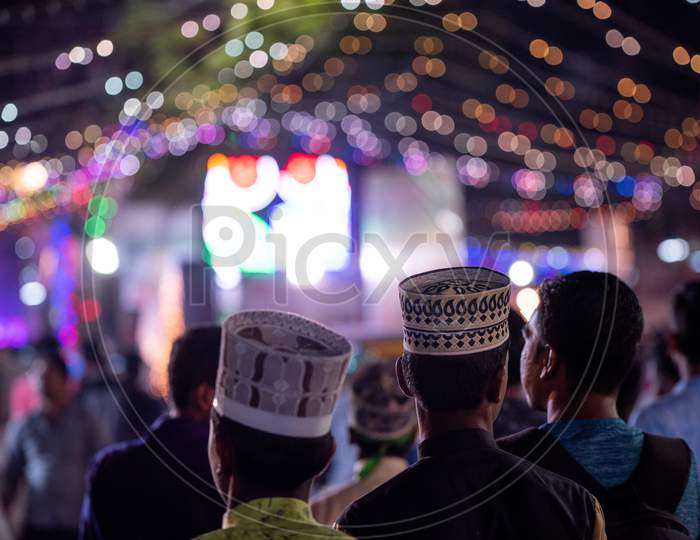 Muslim Devotees Walking In an Street Wearing Caps