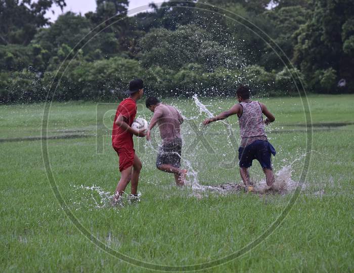 Indian boys having fun in the lawn during rain