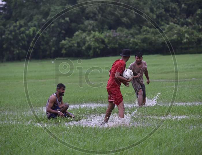 Indian boys playing freestyle football during rain
