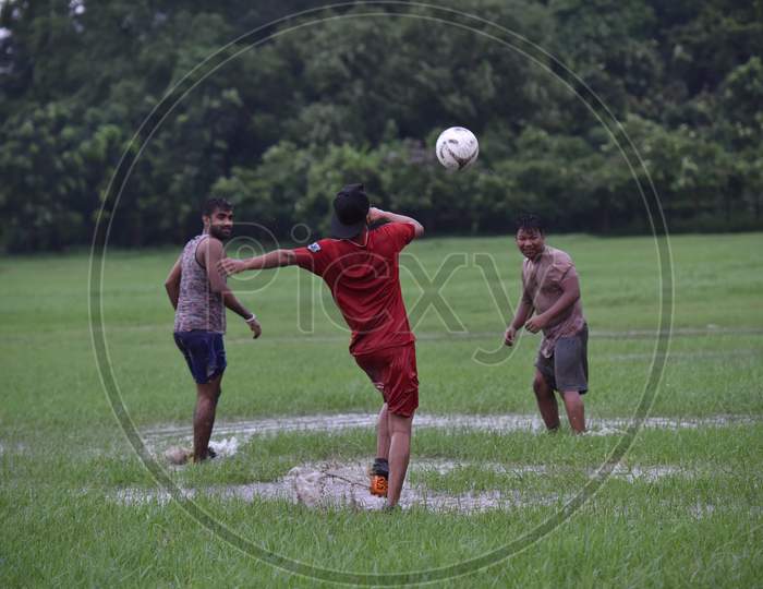 Indian boy attempting a free kick during rain