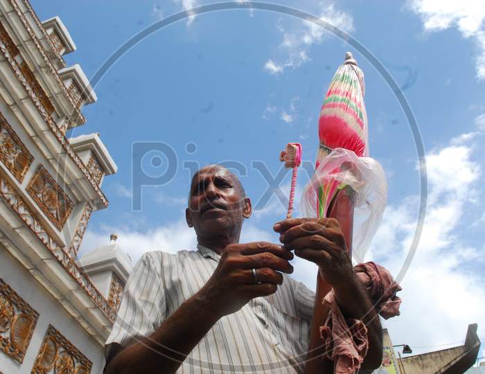 Indian Man making a toothbrush with candy