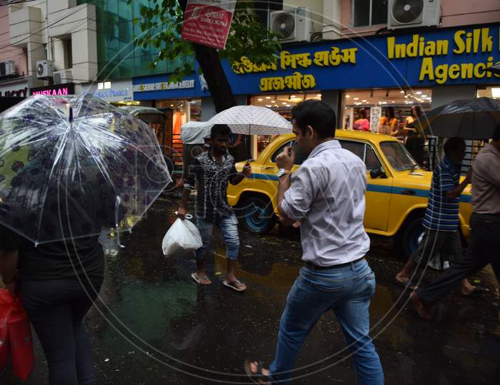 Indians commuting using umbrella in the rain