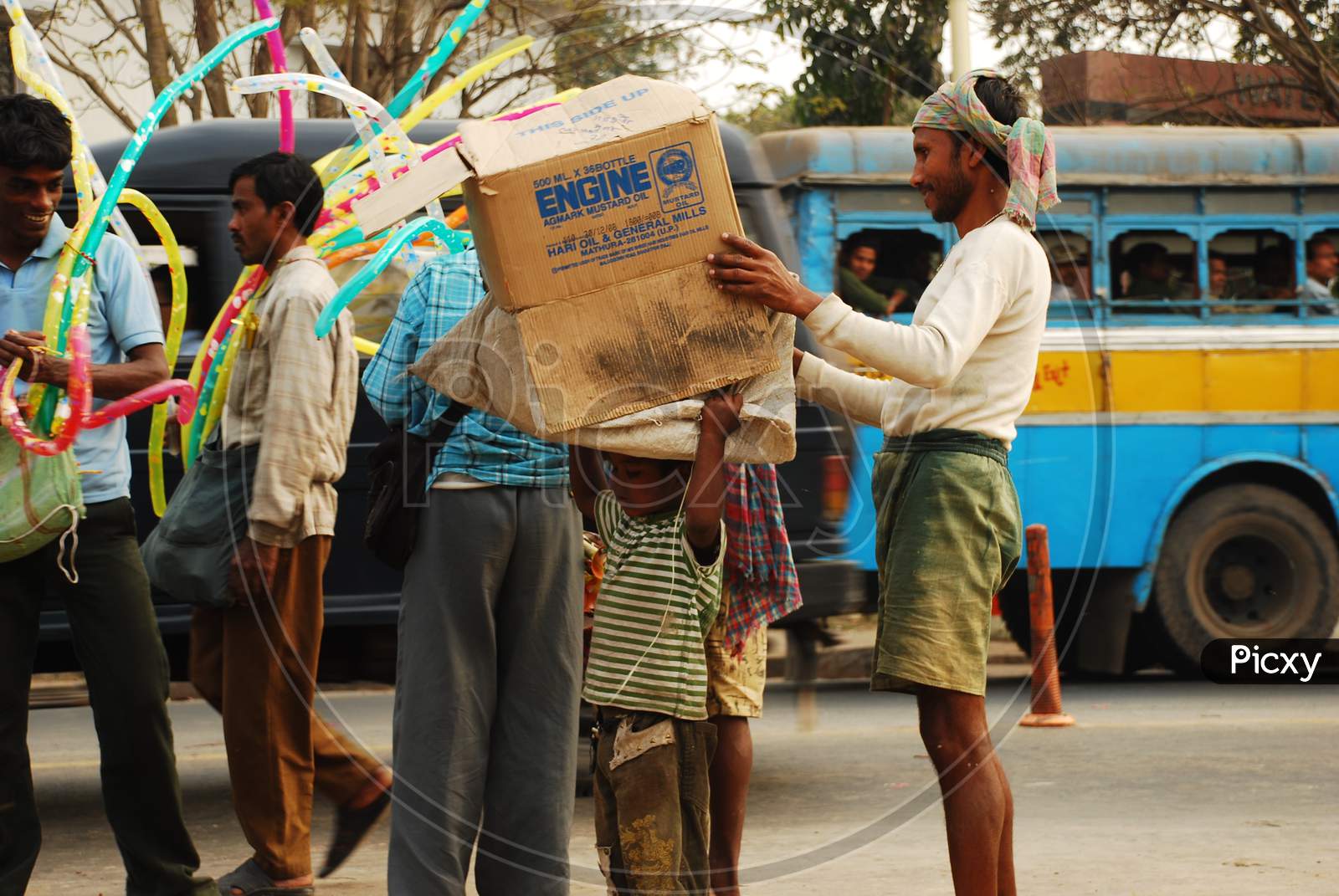 Indian little boy carrying coagulated box on his head