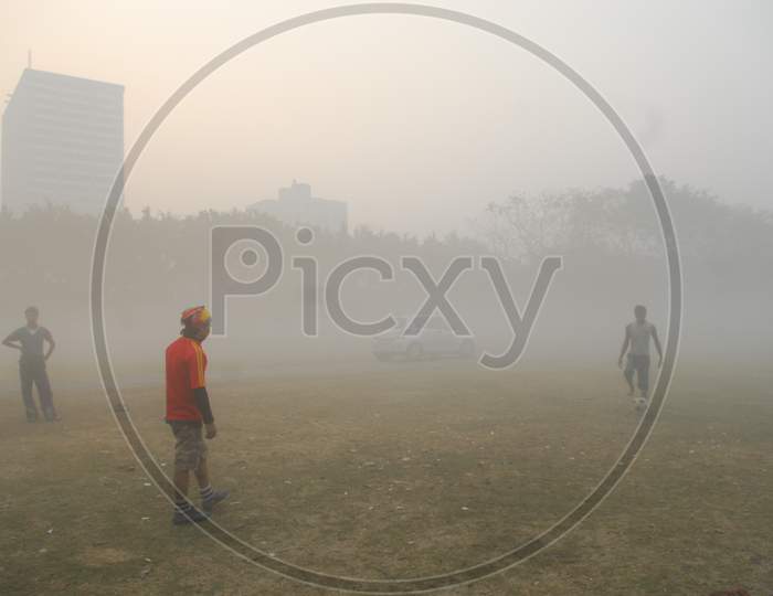 Indian men playing football in heavy fog