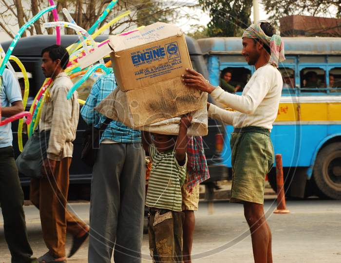 Indian little boy carrying coagulated box on his head