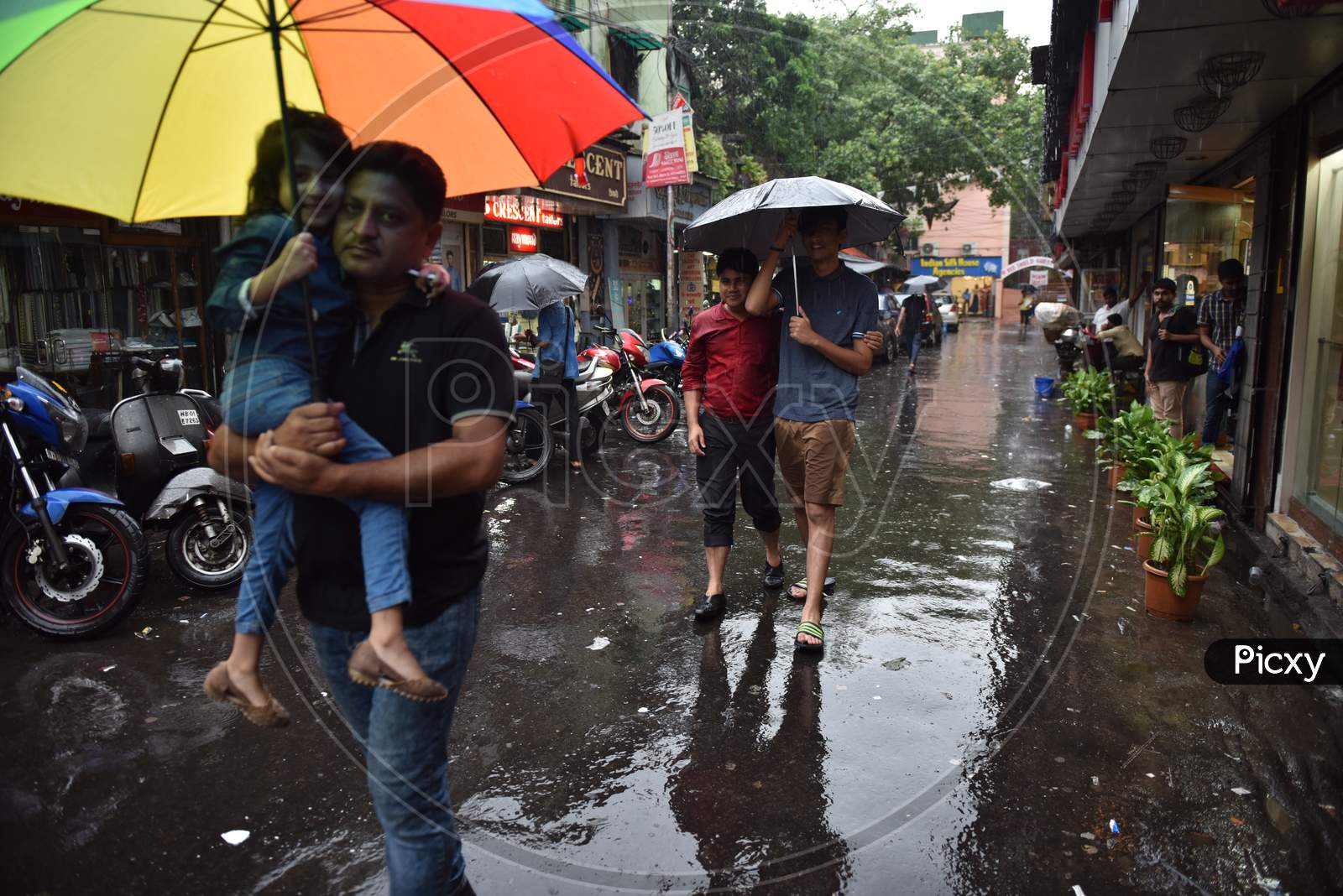 People Walking On Roads Holding Umbrellas During Heavy Rain in Kolkata