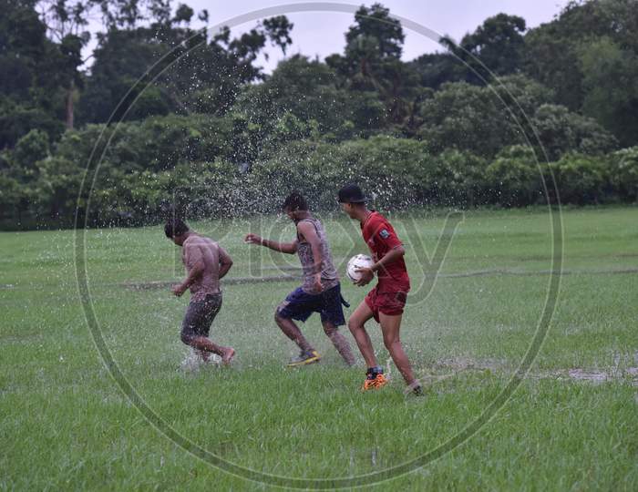 Three Indian boys playing in the rain
