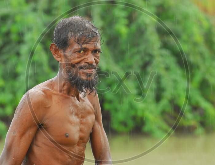 Image Of Indian Bare Chested Man Holding A Shrimp In The Rain Gp100163