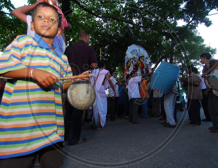 Indian little boy holding a pad and drum
