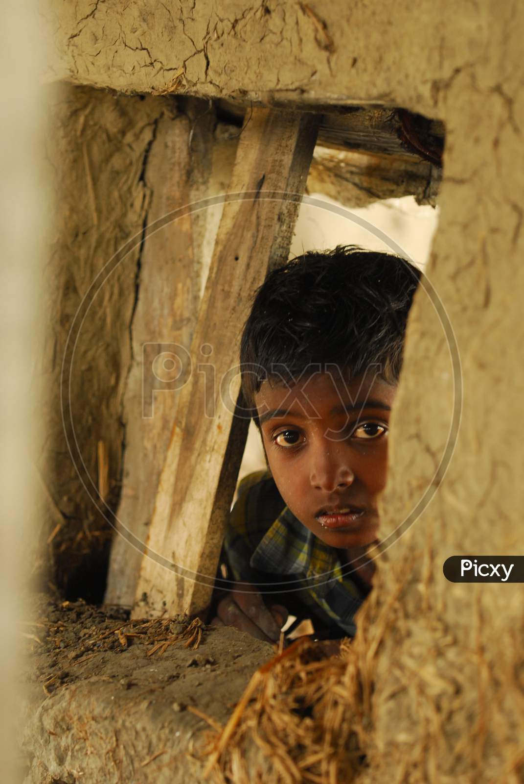 Indian little boy peeping through the wall
