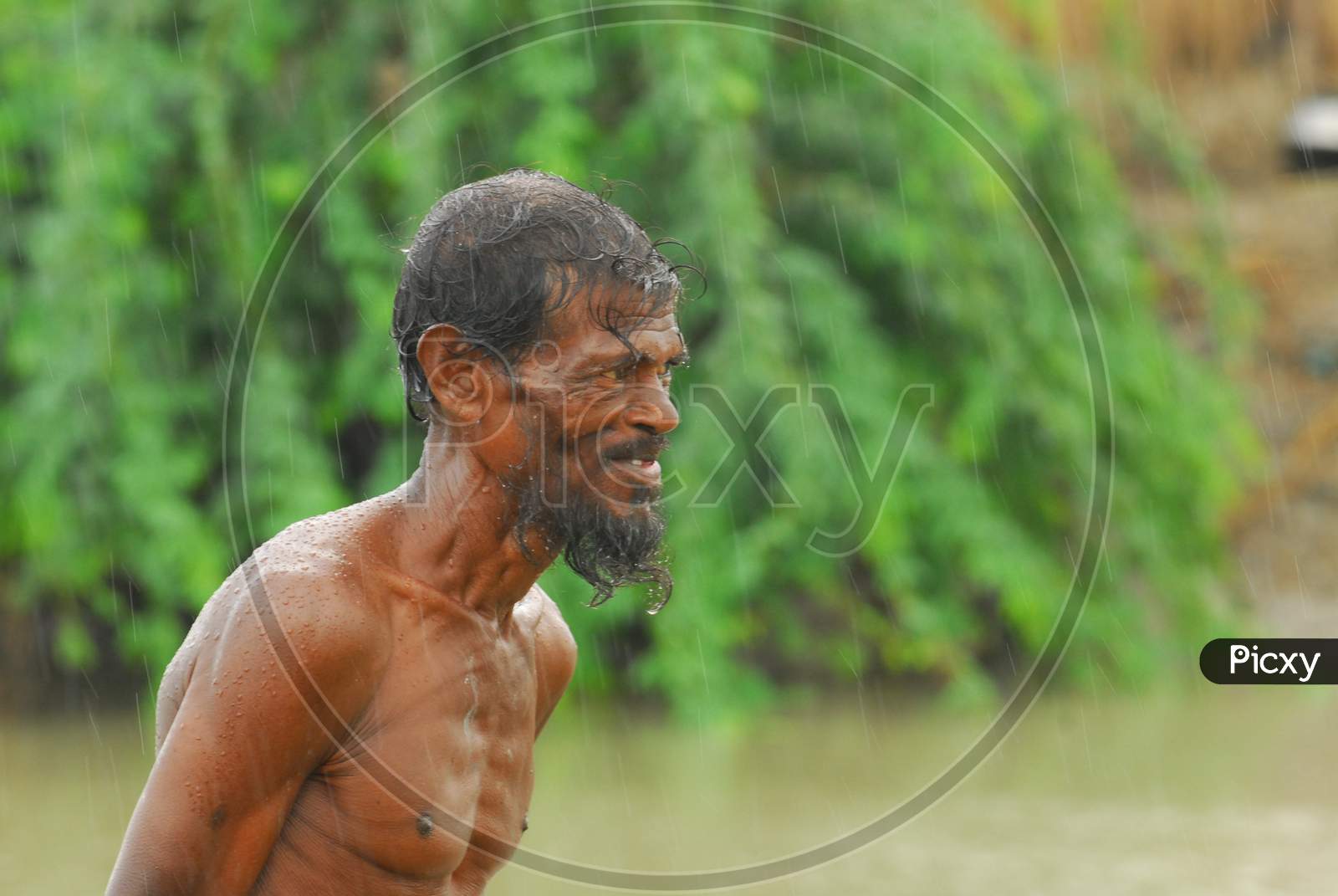 Portrait of Indian bare chested man in the rain