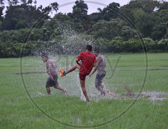Indian boys splashing water on each other during rain