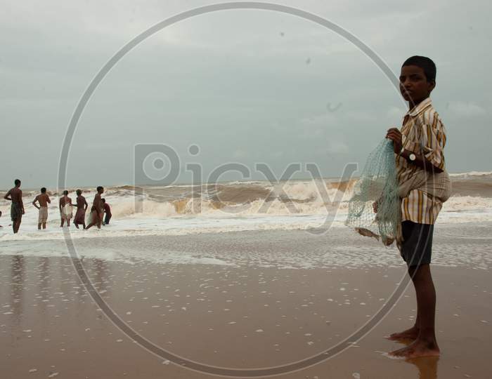 Indian fisher-boy holding fish in the cast net