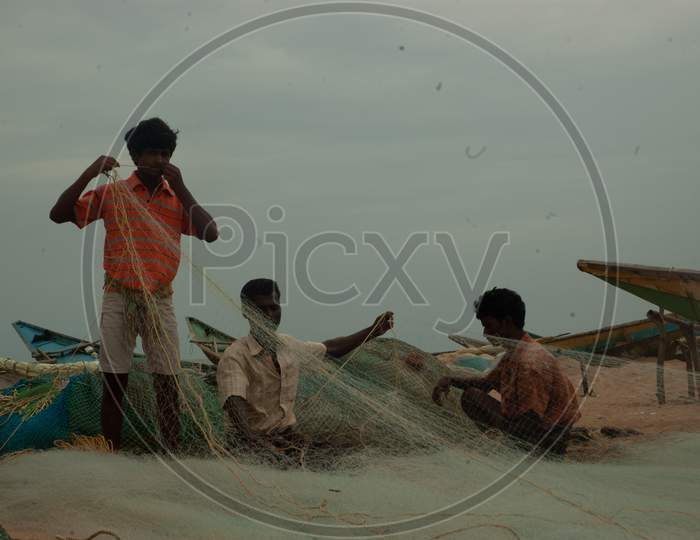 Indian Fishermen tying the fishing nets