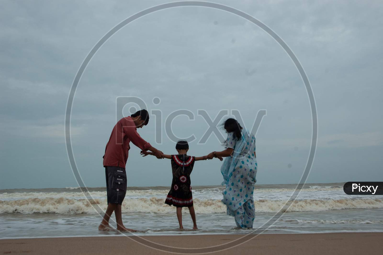 Indian father and mother with their daughter by the beach