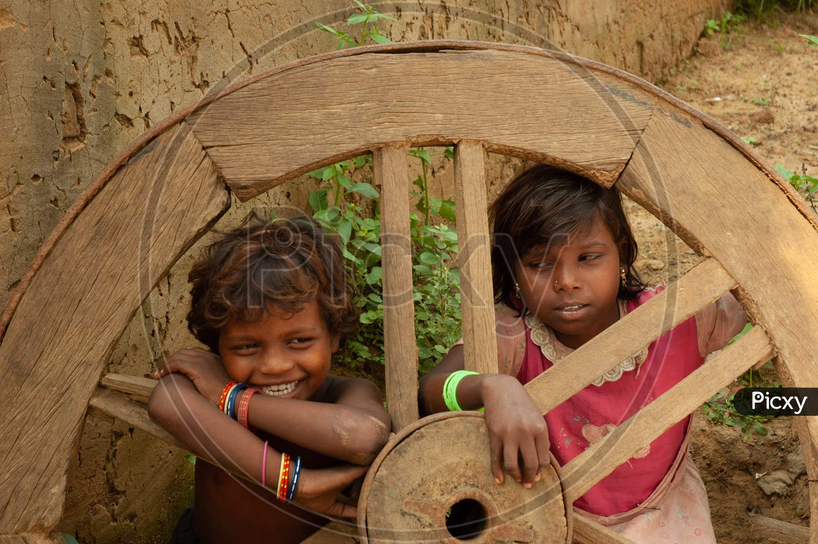 India  Children Playing At an Rural Village At  Bullock Cart Wheel