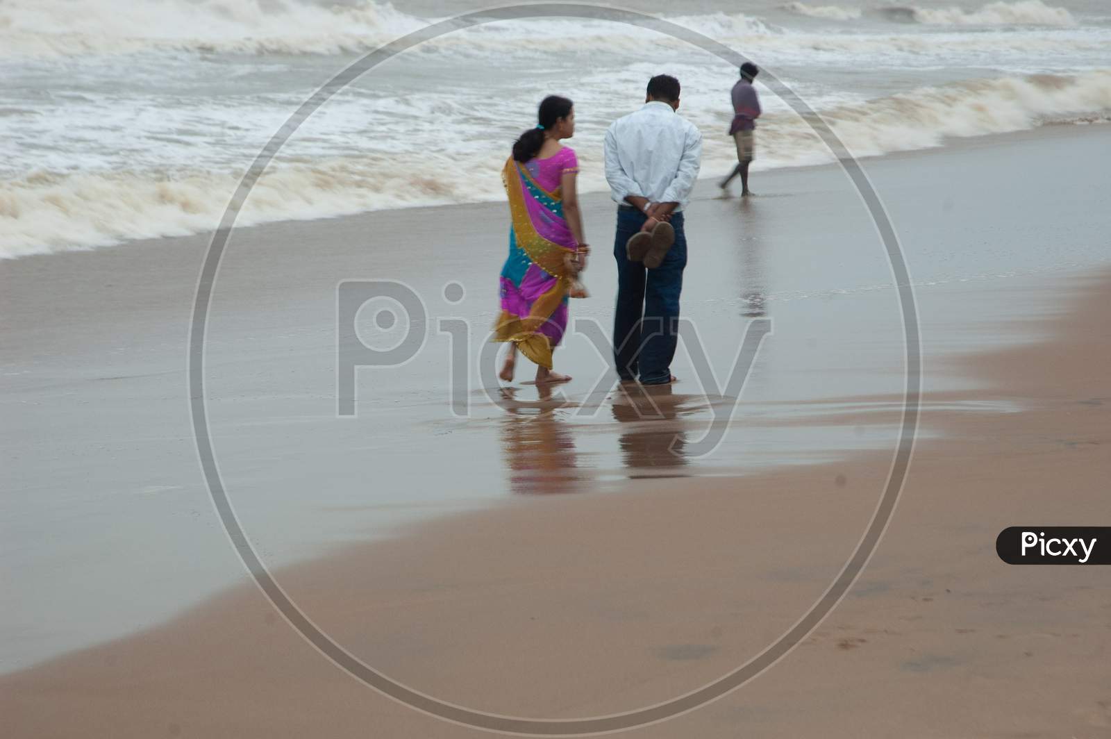Indian Middle aged couple walking by the beach