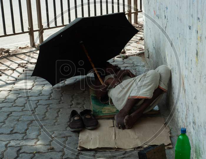 A Nomad Man Sleeping on Footpath
