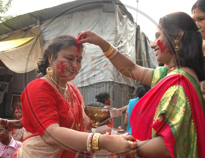 Indian Traditional Woman applying Bindi Powder on forehead during Durga Puja