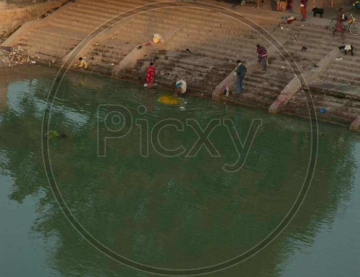 People taking baths by the Jalangi river bank