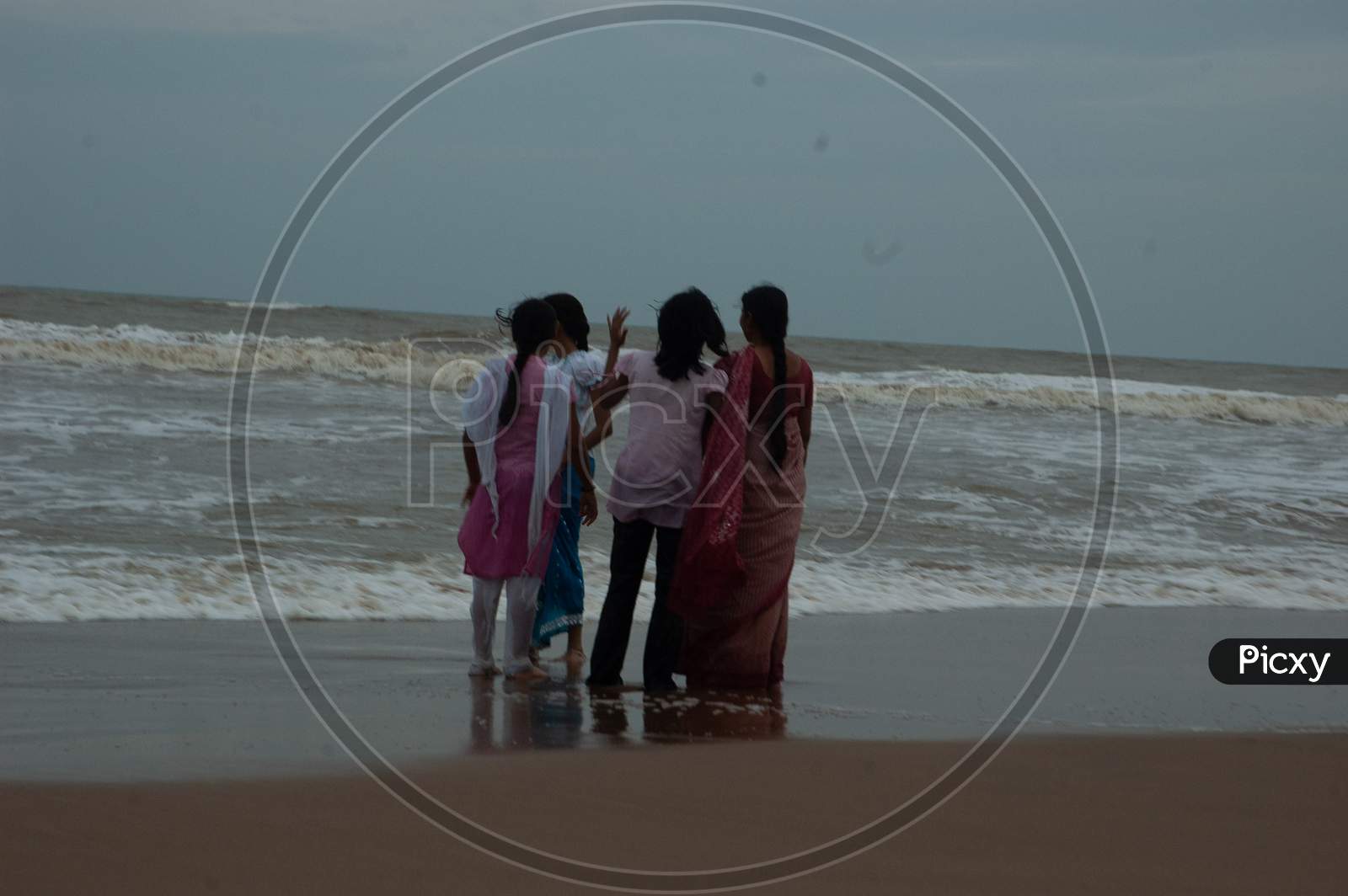 Indian girls standing by the beach during evening
