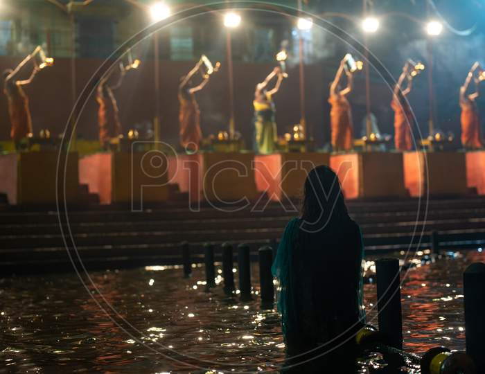 A woman watches Haarathi offering to River Godavari at Pushkar Ghat