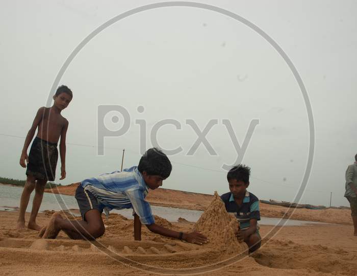 Indian Little boys building sand castles by the beach