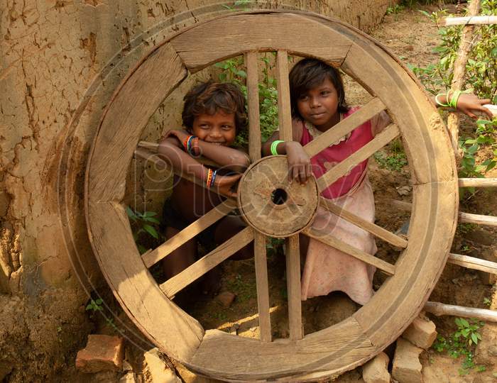 India  Children Playing At an Rural Village At  Bullock Cart Wheel