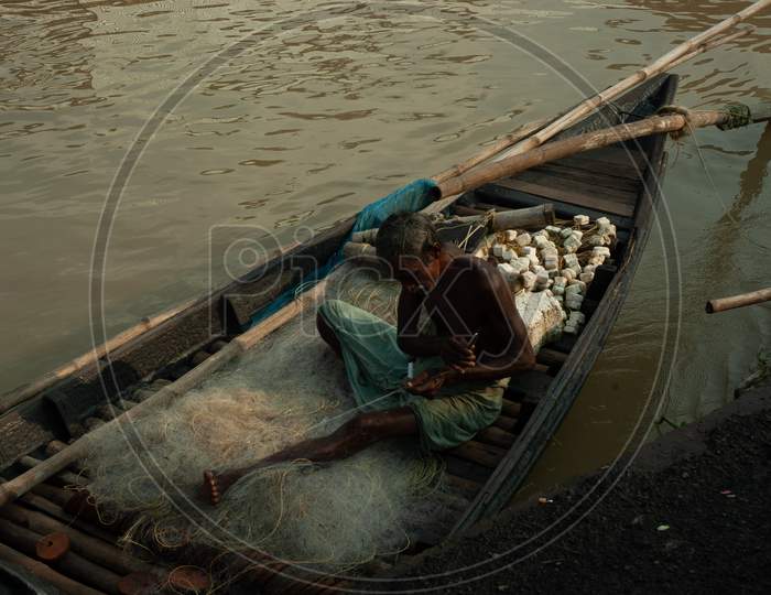 Indian Old Fisherman sewing the cast net