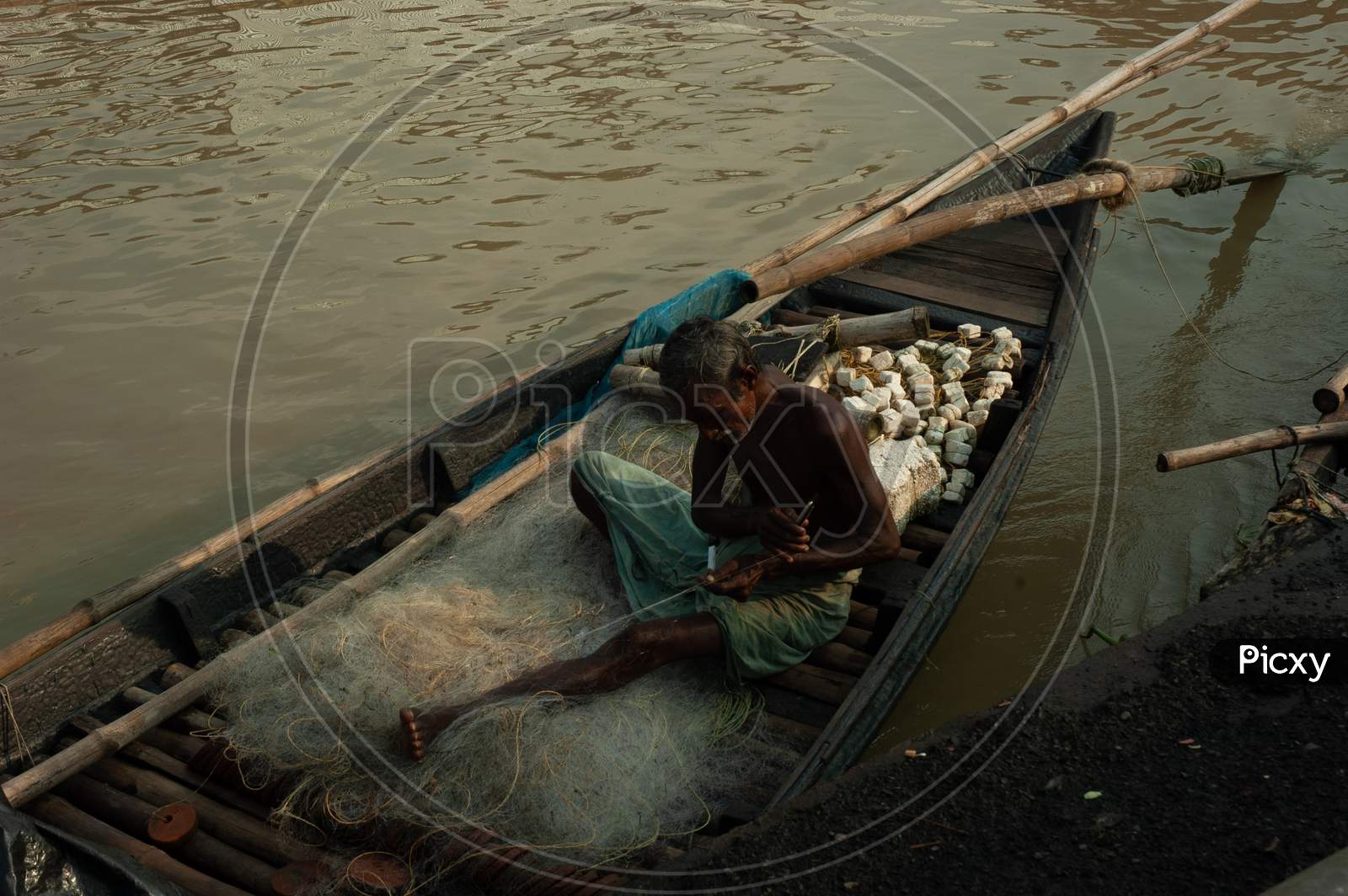 Indian Old Fisherman sewing the cast net