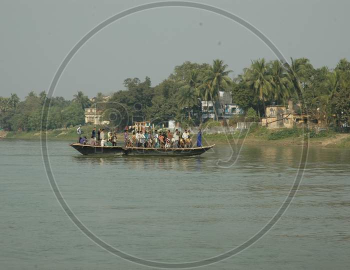 People Commuting On Wooden Boats At Murshidabad Over Hooghly River in West Bengal