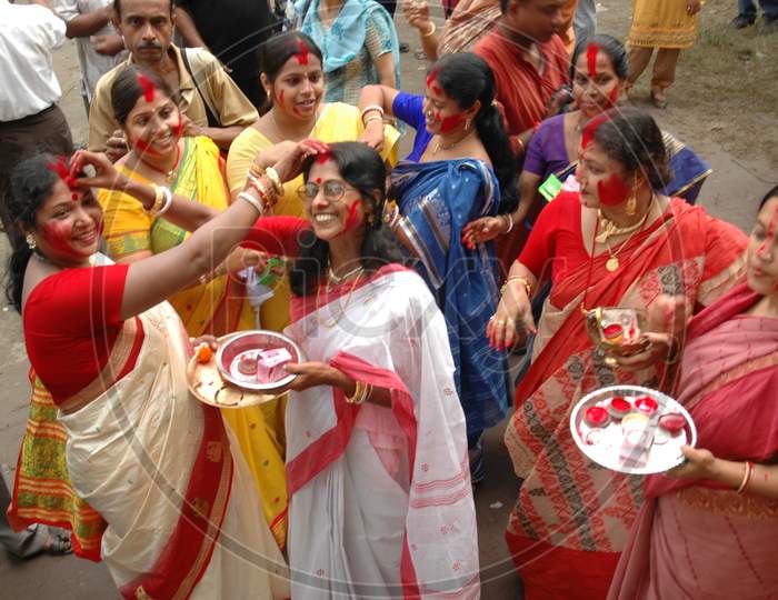 Indian Female Devotees applying Bindi during Durga Puja