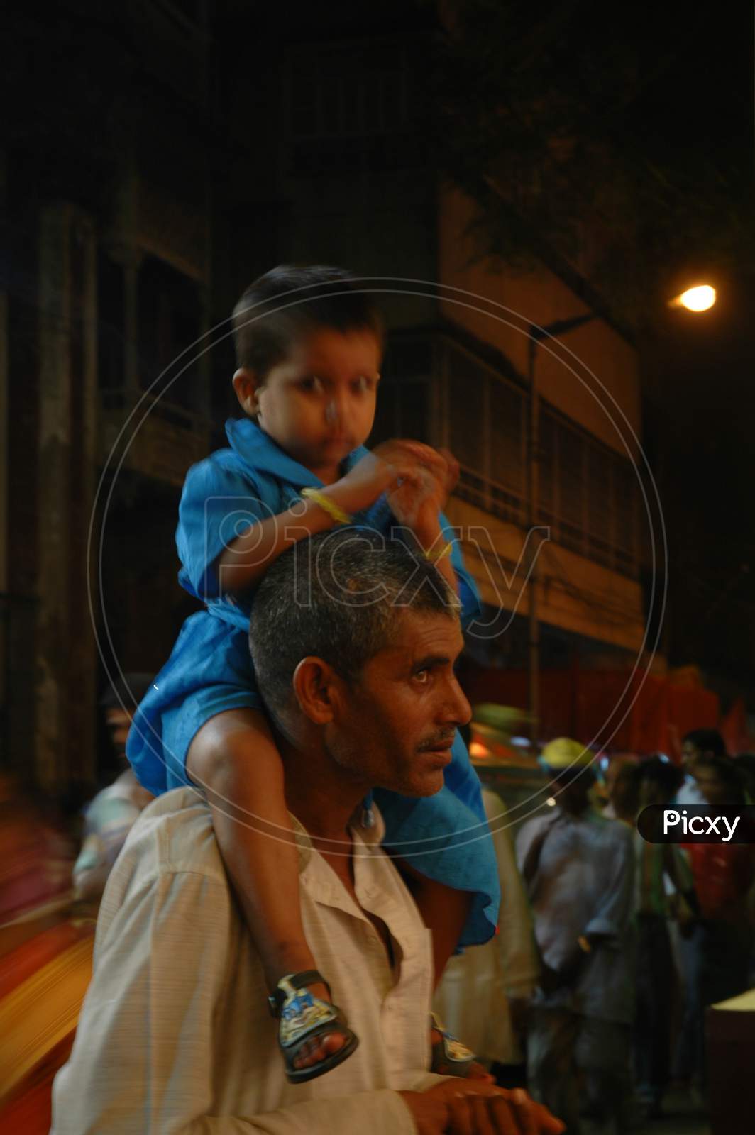 Indian Father carrying his little boy in his shoulders