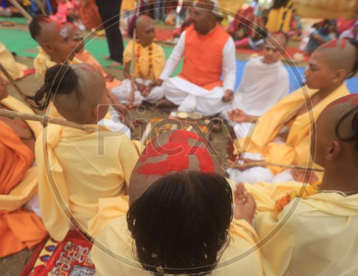 Indian Hindu Bramhin Boy Or Priest  With Swasthik Symbol On Tonsure Head  At Homam During Magh Mela . prayagraj 2020